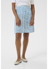 Floral-patterned skirt in light blue with elastic waistband and knee-length cut, paired with beige flat shoes, smooth texture.