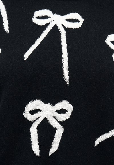 Tissu noir avec des motifs de nœuds blancs tricotés, présentant deux formes de nœuds distinctes avec des queues allongées.