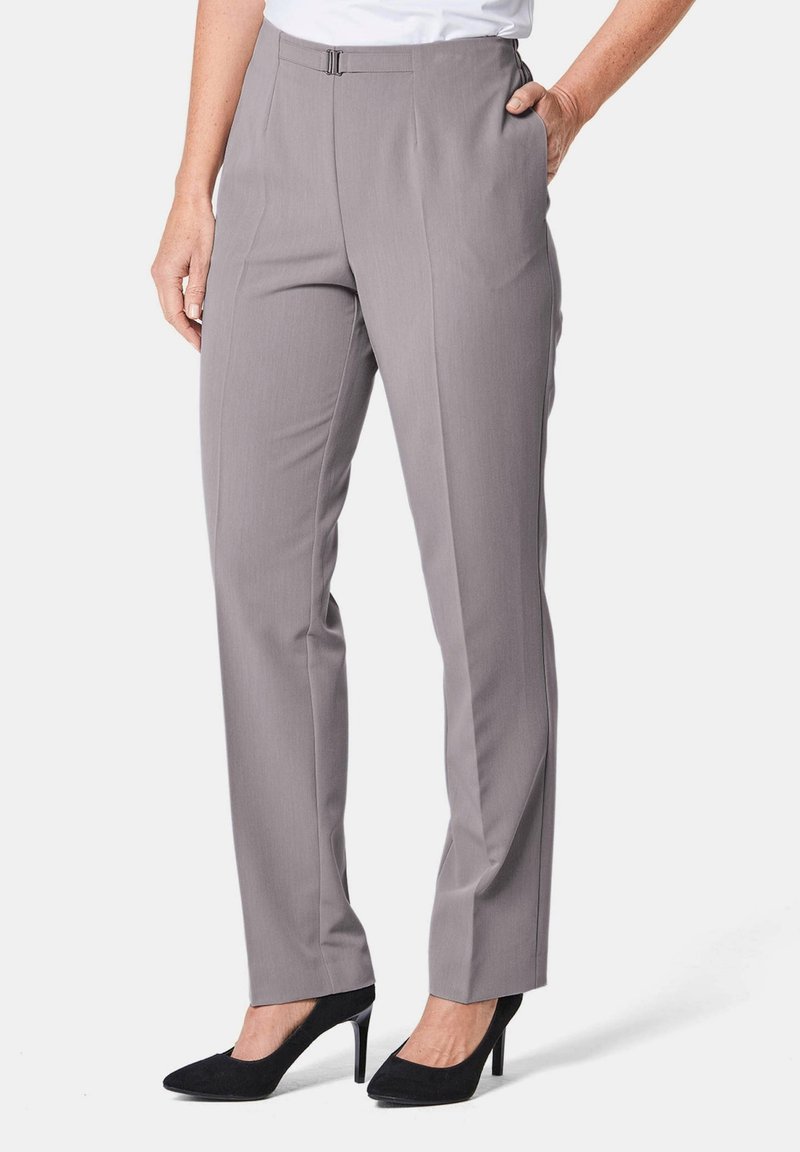 Graue, maßgeschneiderte Hosen mit glatter Textur, ausgestattet mit Fronttaschen und einem dezenten Bundfalten; kombiniert mit schwarzen High-Heels.