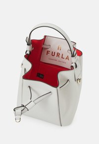 Witte lederen emmerhandtas van echt leer met een rood interieur, een handvat aan de bovenkant en een verstelbare riem. Voorzien van gouden hardware en een logolabel aan de binnenkant.