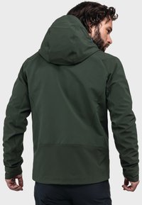 Dunkelgrüne, leichte Kapuzenjacke mit glatter Textur, die Kontur-Nähte und eine entspannte Passform aufweist, von hinten gezeigt.
