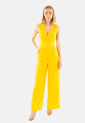 Tuta giallo con scollatura a V profonda e design a gamba larga. Presenta due tasche laterali e una vita aderente. Tessuto liscio e leggero.