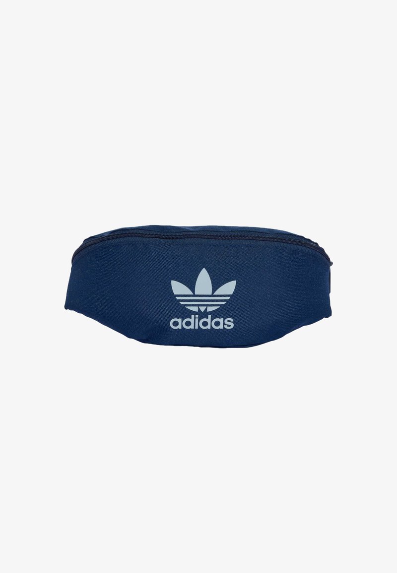Granatowa torba wykonana z tkaniny, z wyraźnym białym logo Adidas w kształcie trifolium oraz zamkiem błyskawicznym na górze. Smukły, zaokrąglony kształt.