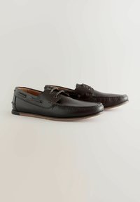 Pantofi din piele neagră cu un finisaj texturat, dotati cu un design cu sireturi, cusături decorative și o talpă din cauciuc. Căptușeală interioară netedă.