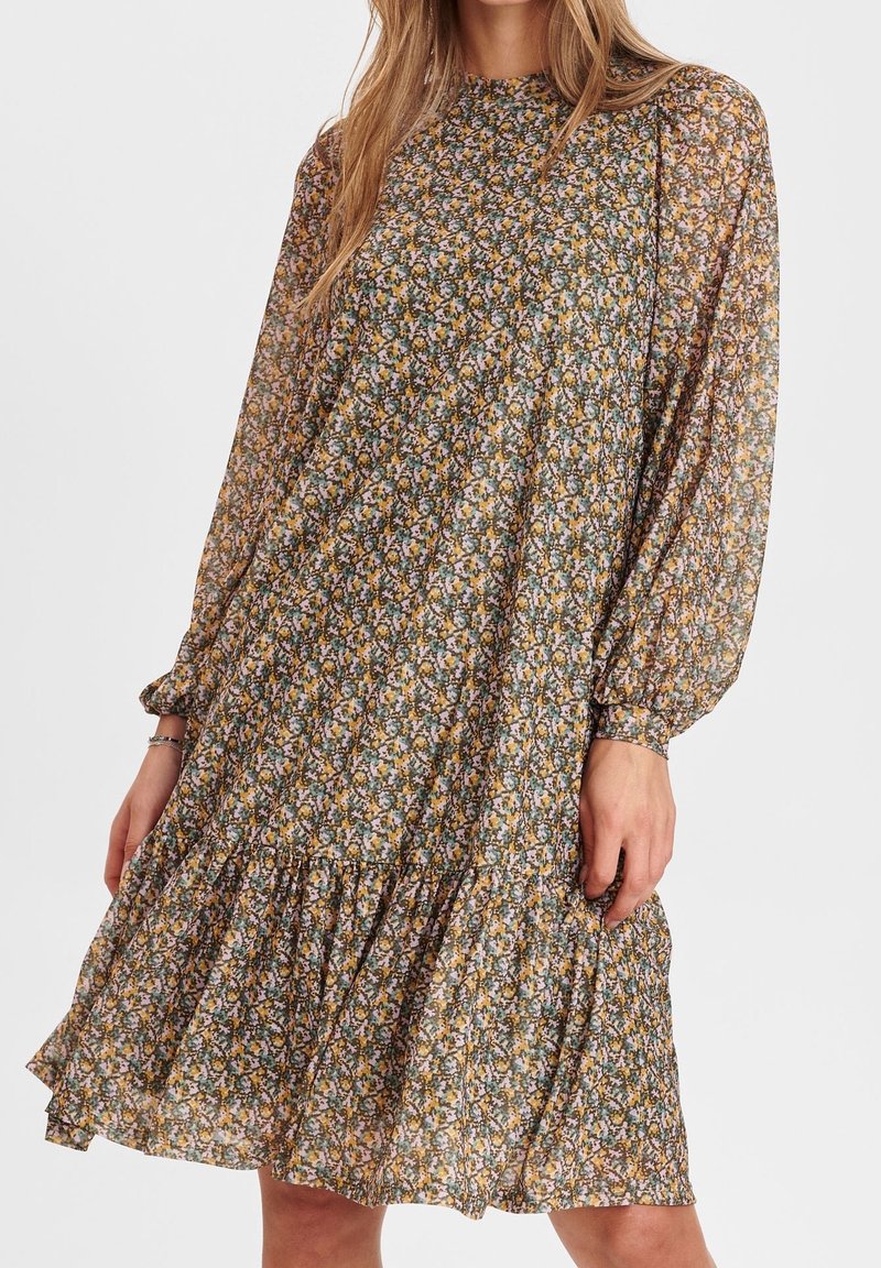 Floral dress featuring long sleeves, a high neckline, and a tiered hem. Made of lightweight fabric in a multicolored floral pattern.