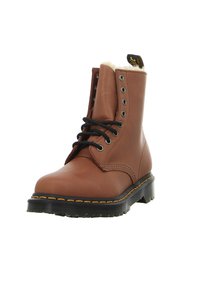 Botas de tobillo de cuero marrón con cordones negros, costuras amarillas y un forro suave. Presenta una punta redonda y una suela de goma resistente.