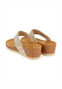Tongs compensées avec une tige synthétique beige, ornées d'un accent en strass sur la bride, d'une semelle intérieure rembourrée beige et d'une semelle en caoutchouc texturée.