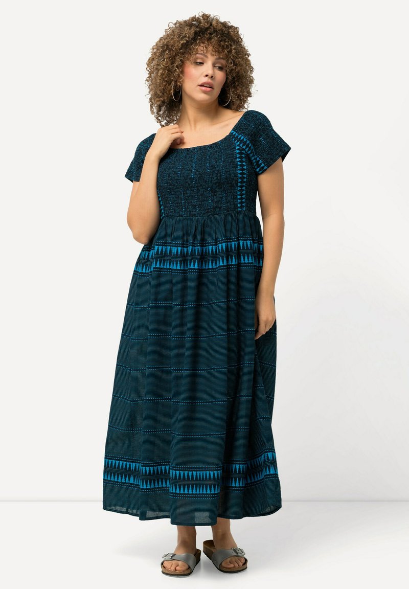 Maximehetki tummansinisestä puuvillasta, jossa on lyhyet hihat, teksturoitu yläosa ja geometriset siniset yksityiskohdat helmoissa ja vyötäröllä.