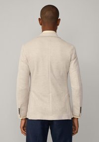 Beige linneblazer med en enda vent, skräddarsydd passform och tre-knäppningsmanschetter. Har en slät yta och en minimalistisk design.
