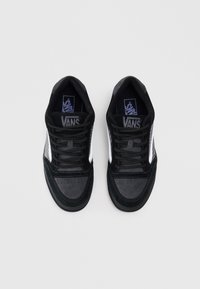 Sneaker Vans neri con pannelli laterali in rete, dettagli in suede sulla punta e sul tallone, lacci neri piatti e suola in gomma. Logo discreto sulla linguetta.