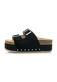Sandalias de plataforma de ante negro con dos correas ajustables, hebillas plateadas, suela de corcho texturizada y acentos de tachuelas a lo largo de la base.