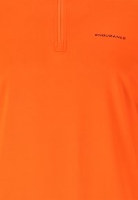 Orange polo shirt i lättviktsmaterial, med en halvdragkedja och en subtil logotyp. Slät textur med en figurnära design.