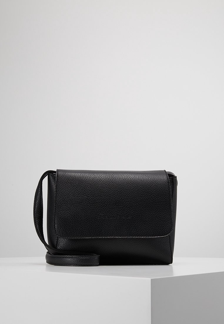 Czarna torebka crossbody z fakturowanej skóry, z klapką i regulowanym paskiem, wyeksponowana na białym cokole na szarym tle.