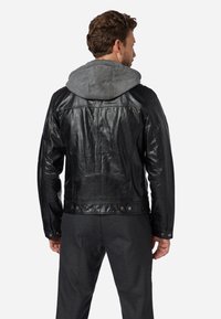 Schwarze Lederjacke mit einer grauen Kapuze, die eine glatte Textur, eine taillierte Passform und sichtbare Metallakzente an der Taille und den Ärmelabschlüssen aufweist.