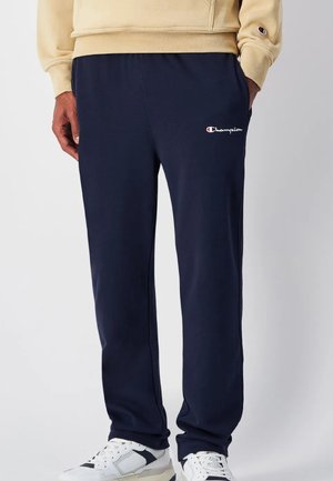 Marinefarbene Jogginghosen aus weichem Stoff mit einem elastischen Bund. Sie verfügen über ein kleines weißes und rotes Logo auf dem oberen linken Oberschenkel.