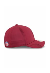Rote Kappe aus Stoff mit einem gebogenen Schirm. Verfügt über Mesh-Einsätze für Belüftung und ein NFL-Logo-Patch an der Seite.