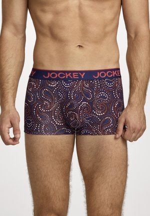 Male torso wearing navy blue boxer briefs with red and white dotted paisley patterns and a navy waistband with "JOCKEY" in red letters.