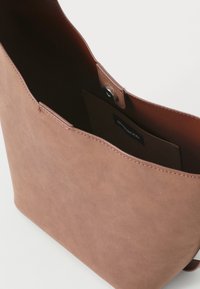 Brun faux skinnveske med en glatt tekstur, åpen topp og en magnetisk trykklås. En innvendig lomme er synlig.