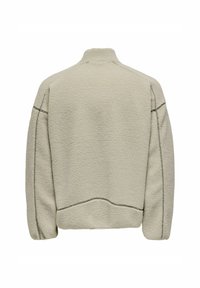 Giacca in pile beige con collo alto, caratterizzata da una superficie testurizzata, cuciture a vista e una vestibilità comoda. La vista posteriore non mostra chiusure.