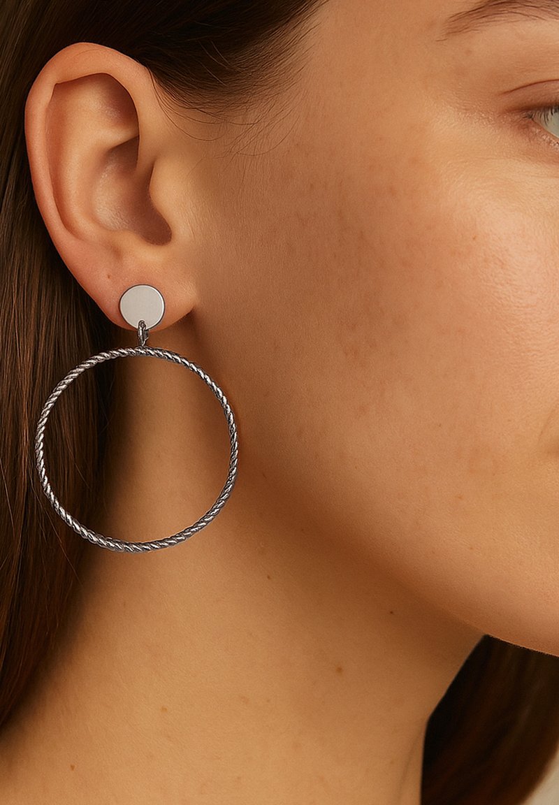 Metal hoop earrings with a twisted design. The top features a small circular stud, both in a silver tone. Textured and polished finish.