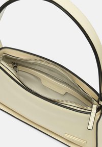 Borsa a spalla in pelle beige con profili neri, dotata di chiusura con zip e compartimenti interni per l'organizzazione. Texture liscia.
