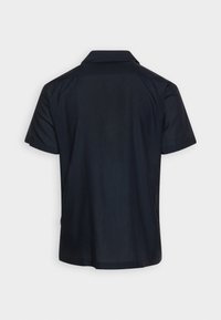 Polo majica s kratkimi rokavi v temno mornarsko modri barvi, z klasičnim ovratnikom, gladkim materialom in ravnim robom ter subtilno oznako logotipa na strani.