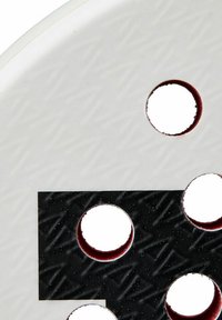 Cirkulär produkt med en texturerad vit yta och ett svart område, med flera runda utklipp som omger en glänsande kant.