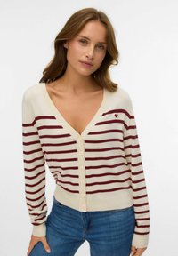 Cream cardigan with burgundy stripes, V-neckline, front buttons, and a small red heart motif on the left chest. Soft knit texture.