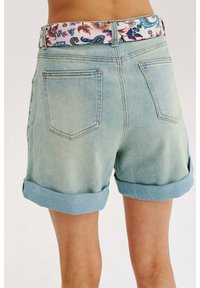 Džínové šortky s bledomodrým umývaním, s obrúbenými okrajmi a vzorovaným pásom s kvetinovými a paisley vzormi. Viditeľné zadné vrecká.