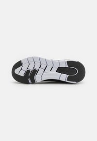 Čierno-biele športové tenisky so silnou gumovou podrážkou, s textúrovaným povrchom, obsahujúce cik-cak vzor a logo Reebok blízko päty.