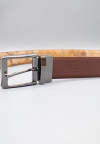 Cintura in pelle marrone con una texture liscia e fibbia in metallo argentato. Presenta un logo in rilievo e una fodera interna più chiara a contrasto.