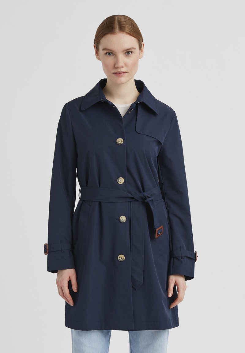 Dunkelblauer Trenchcoat aus glattem Stoff, mit Kragen, goldenen Knöpfen und einem abnehmbaren Gürtel mit braunen Lederakzenten.