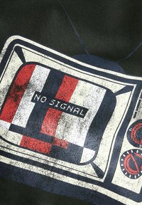 Czarne tło z grafiką vintydżowego telewizora z zniszczonym ekranem wyświetlającym napis "BRAK SYGNAŁU" w białym kolorze, ozdobione czerwonymi i niebieskimi paskami.