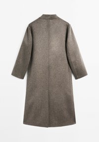 Lang, op maat gemaakte jas van een gestructureerde bruine stof, met een rechte silhouet, grote mouwen en een eenvoudig kraagontwerp.