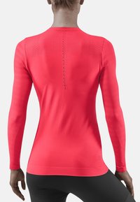 Sportovní tričko s dlouhým rukávem v jasně růžové barvě, se strukturálními panely a perforovanými detaily na zádech, přiléhavý střih a žebrované manžety.