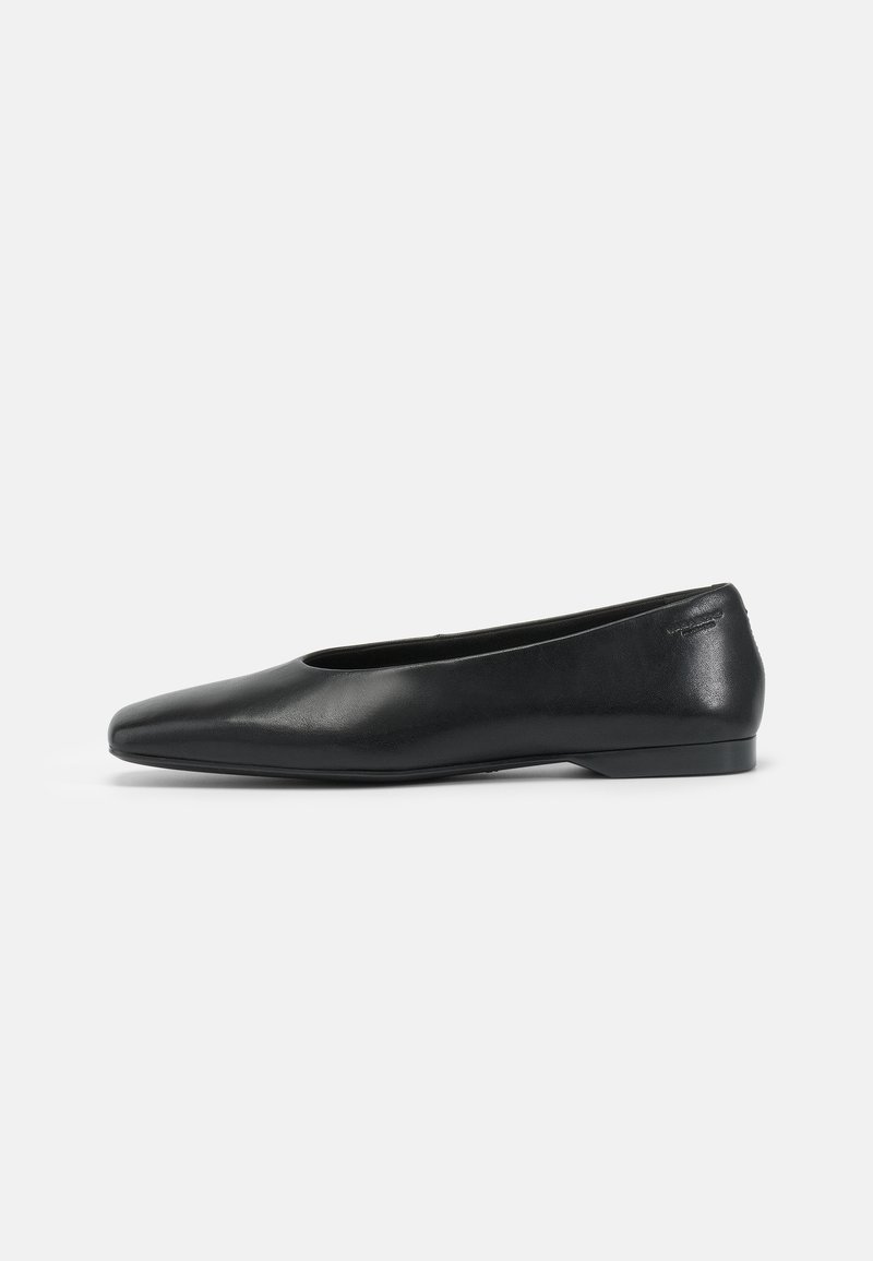 Chaussure plate en cuir noir avec un bout pointu et un talon bas, vue de profil sur un fond blanc uni.