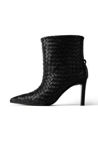 Czarny, pleciony skórzany botek za kostkę z wąskim noskiem i cienkim obcasem w kształcie szpilki. Posiada teksturowaną powierzchnię oraz pętelkę z tyłu.
