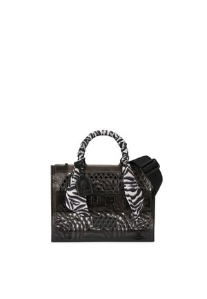 Bolso rectangular transparente negro con patrón de rejilla, asa envuelta en tela con rayas de cebra, correa de hombro negra desmontable y etiqueta colgante.
