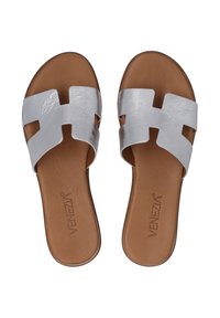 Slide-sandalen met een metallic zilveren synthetische bovenkant en een tan leren voetbed. Beschikt over een uitgesneden ontwerp en een platte zool.