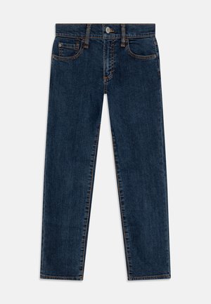 Jean en denim bleu foncé à jambe droite avec bouton et fermeture éclair à l'avant, passants pour ceinture et style cinq poches, posé à plat sur un fond blanc.