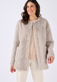 Lichtgrijze nepbontjas met een gestructureerd chevronpatroon, voorzien van gouden knopen en zijzakken. Ronde halslijn en een relaxte pasvorm.