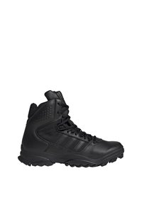 Bottines tactiques noires en cuir et en matériau synthétique, avec un design montante, des accents texturés et une semelle en caoutchouc robuste.