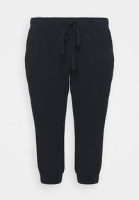 Czarne spodnie dresowe z elastycznym pasem i regulowanym sznurkiem. Ze ściągaczami przy kostkach, z bocznymi kieszeniami o gładkiej fakturze.