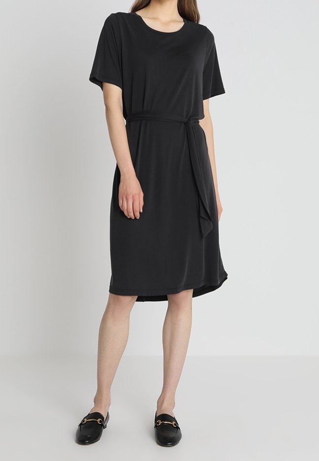 Robe noire à manches courtes avec une coupe ample, cintrée à la taille par une ceinture assortie. Tissu jersey lisse, longueur au genou, encolure ronde.