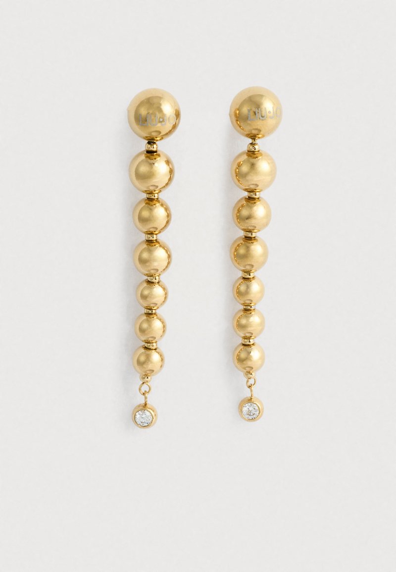 Arany színű fülbevalók, amelyek sorozatnyi gömb alakú gyöngyökkel és egy kis lógó kristálydíszítőelemmel rendelkeznek az alján. Simább, csiszolt felület.