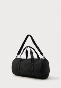 Czarna torba sportowa z dwoma górnymi uchwytami i regulowanym paskiem. Wyposażona w plecioną markę "TOMMY JEANS" na paskach. Gładka faktura materiału.