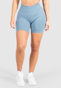 Hoge taille blauwe sport shorts gemaakt van rekbaar materiaal, met een gladde textuur en een strakke pasvorm, gecombineerd met witte sport schoenen.
