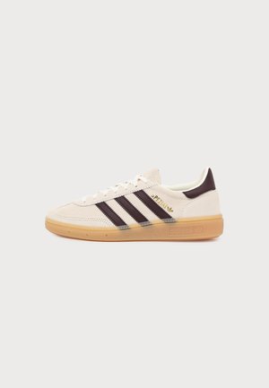 Baskets Adidas en daim crème avec bandes marron, texte doré « "Spezial" » et semelle en gomme beige, présentée de profil sur fond blanc.