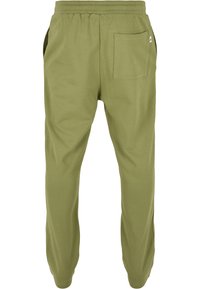 Groene katoenen joggers met een elastische tailleband, taps toelopende benen en een enkele achterzak. Glad textuur zonder zichtbare patronen.
