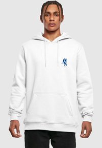 Sudadera blanca con bolsillo canguro, capucha con cordón y logo gráfico azul en el pecho. Textura de tela suave y ajuste relajado.